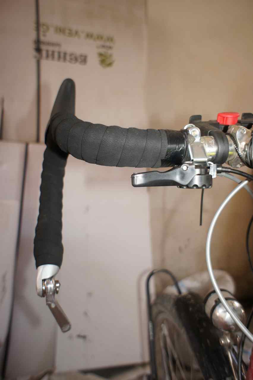 My new shifter set up. The broken shifter hangs dead at the barend and the new is upside down close to the stem.